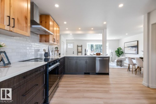 Modern kitchen featuring two-tone cabinetry with black hardware, white subway tile backsplash, and stainless steel appliances - 4508 109A Avenue, Edmonton, AB - Indoor Photo Showing Kitchen With Upgraded Kitchen