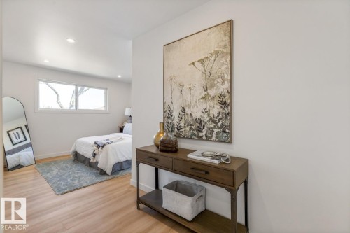 Hallway featuring a built-in console table with metal accents and wood-finish flooring - 4508 109A Avenue, Edmonton, AB - Indoor