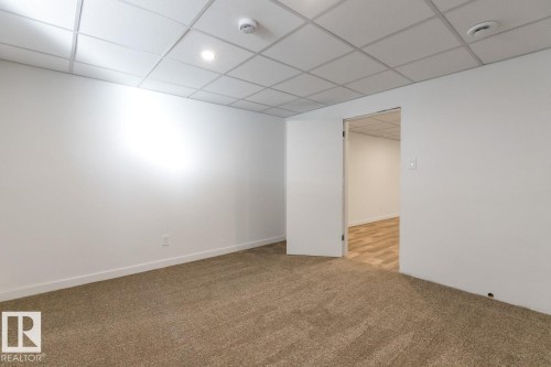 Versatile interior space featuring light beige carpeting, white walls, and a drop ceiling with recessed lighting - 4508 109A Avenue, Edmonton, AB - Indoor Photo Showing Other Room