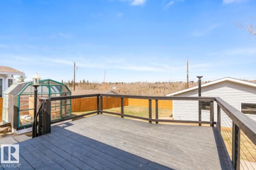 Expansive dark wood-finish deck with cable railing - 4508 109A Avenue, Edmonton, AB - Outdoor With Exterior