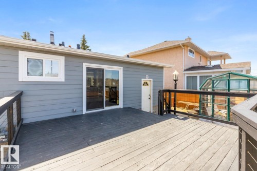 Expansive wood deck with dark-stained railing featuring clear panel infill - 4508 109A Avenue, Edmonton, AB - Outdoor With Deck Patio Veranda With Exterior