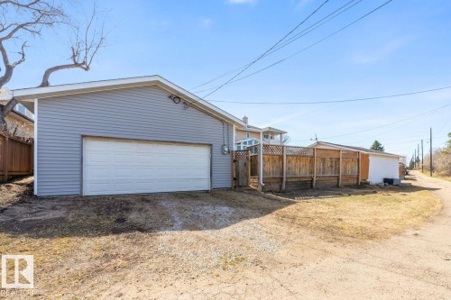 Detached garage with horizontal siding, a white overhead door, and exterior lighting - 4508 109A Avenue, Edmonton, AB - Outdoor With Exterior