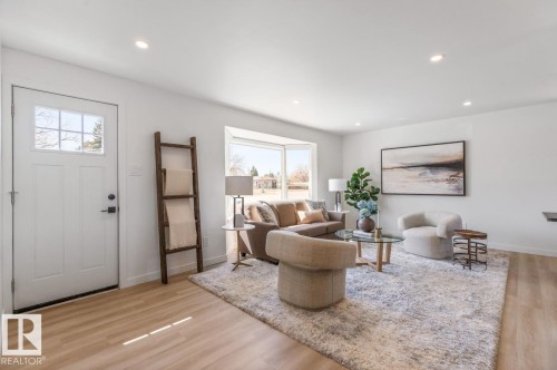 Bright living space featuring recessed lighting, light wood-finish flooring, and a multi-pane front door - 4508 109A Avenue, Edmonton, AB - Indoor Photo Showing Living Room