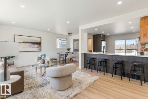 Light wood-finish flooring extending into the dining area - 4508 109A Avenue, Edmonton, AB - Indoor Photo Showing Other Room