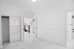 Spacious room featuring white walls, white baseboards, and a decorative chair rail molding - 