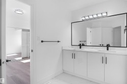 Dual vanity featuring white cabinetry, integrated sinks, and matte black fixtures - 