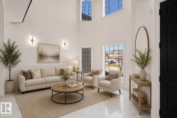 Two-story living area featuring white wall paneling, a double-height ceiling, and large arched windows - 