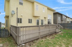 Spacious rear deck featuring wood railings and stairs, offering outdoor living space - 