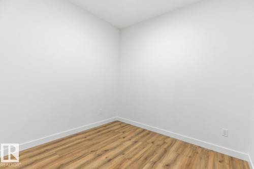 Room featuring wood-finish flooring, white baseboards, and neutral wall tones - 6625 46 Avenue, Beaumont, AB - Indoor Photo Showing Other Room