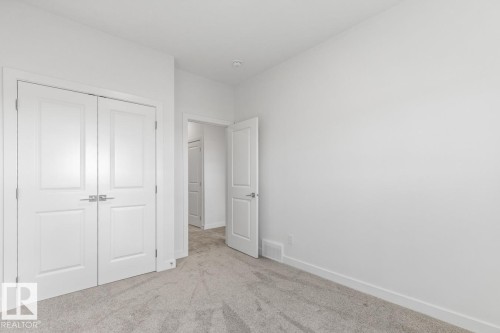 Spacious room featuring light gray carpet flooring, white walls, and bright white trim - 6625 46 Avenue, Beaumont, AB - Indoor Photo Showing Other Room