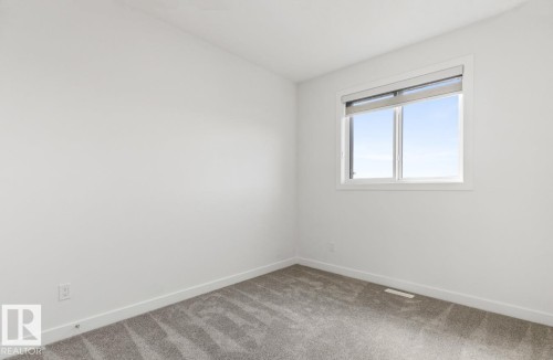 Neutral-toned room featuring a single window with blinds, light gray carpet, and white baseboards - 6625 46 Avenue, Beaumont, AB - Indoor Photo Showing Other Room