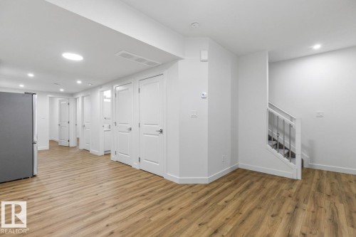 Spacious interior featuring wood-finish flooring, white walls, and a recessed lighting system - 6625 46 Avenue, Beaumont, AB - Indoor Photo Showing Other Room