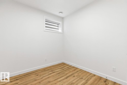 Interior room with light wood-finish flooring and white baseboards - 6625 46 Avenue, Beaumont, AB - Indoor Photo Showing Other Room