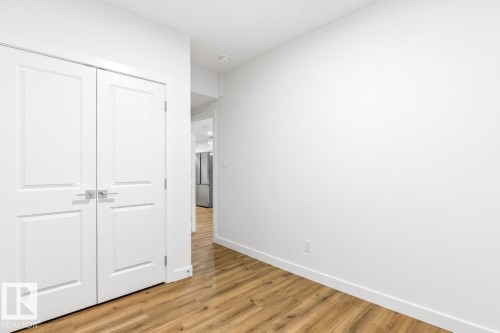 White bi-fold closet doors with polished chrome hardware - 6625 46 Avenue, Beaumont, AB - Indoor Photo Showing Other Room