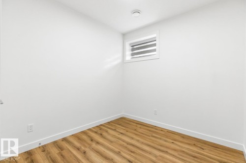 Compact room featuring wood-finish flooring and a white baseboard - 6625 46 Avenue, Beaumont, AB - Indoor Photo Showing Other Room