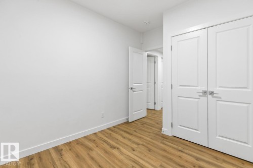 Room featuring wood-finish flooring, crisp white walls, and a recessed ceiling light - 6625 46 Avenue, Beaumont, AB - Indoor Photo Showing Other Room