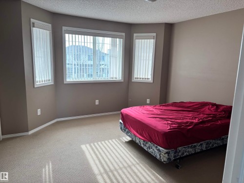 This property features a room with light-colored carpeting and neutral-toned walls - 11904 18 Avenue, Edmonton, AB - Indoor Photo Showing Bedroom