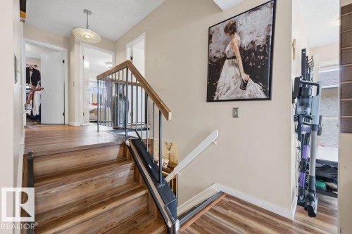 Staircase featuring wood-finish treads and risers, black metal balusters, and a wood handrail - 7422 188 Street, Edmonton, AB - Indoor Photo Showing Other Room