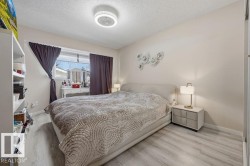 Spacious room featuring light wood-finish flooring, a ceiling-mounted light fixture, and neutral wall paint - 