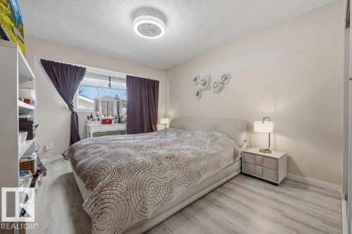 Spacious room featuring light wood-finish flooring, a ceiling-mounted light fixture, and neutral wall paint - 7422 188 Street, Edmonton, AB - Indoor Photo Showing Bedroom