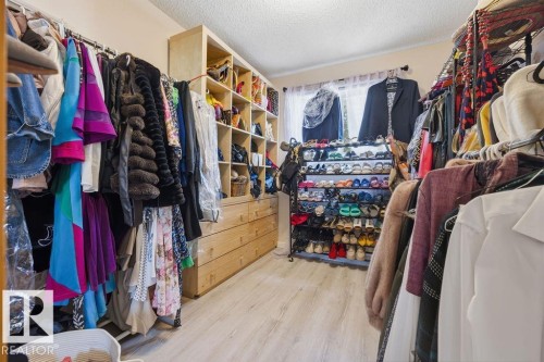 Custom closet system featuring wood-finish cabinetry and drawers - 7422 188 Street, Edmonton, AB - Indoor With Storage