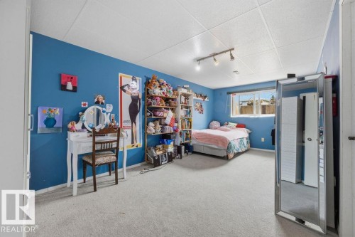 Spacious room with light gray carpeting and blue painted walls - 7422 188 Street, Edmonton, AB - Indoor Photo Showing Other Room