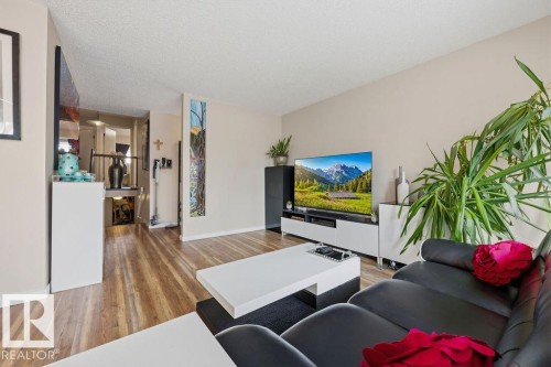 Spacious living area featuring wood-finish flooring, a neutral wall palette, and a textured ceiling - 7422 188 Street, Edmonton, AB - Indoor Photo Showing Living Room