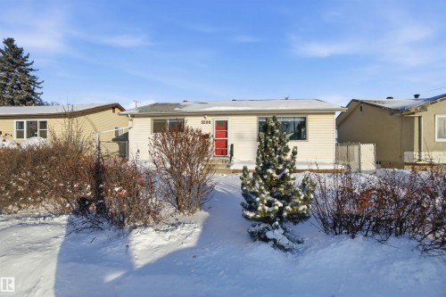 The property features a single-story design with white siding and a prominent red front door - 5208 90 Avenue, Edmonton, AB - Outdoor