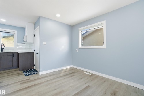 This space features light-toned flooring, light blue walls, and recessed lighting - 5208 90 Avenue, Edmonton, AB - Indoor Photo Showing Other Room