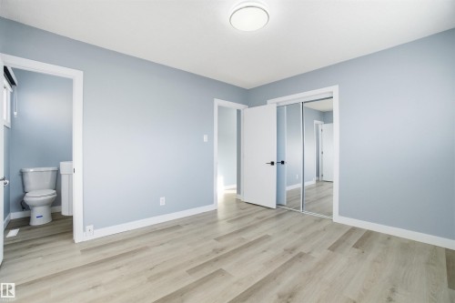 This room offers light-toned flooring, light blue walls, and white trim throughout - 5208 90 Avenue, Edmonton, AB - Indoor Photo Showing Other Room
