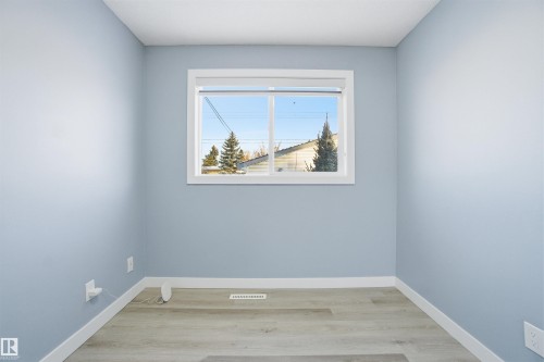 Interior room featuring light blue walls, light-colored flooring, and a window with white trim - 5208 90 Avenue, Edmonton, AB - Indoor Photo Showing Other Room