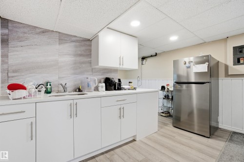 Kitchenette featuring white cabinetry, a stainless steel refrigerator, and light wood-style flooring - 5208 90 Avenue, Edmonton, AB - Indoor Photo Showing Kitchen