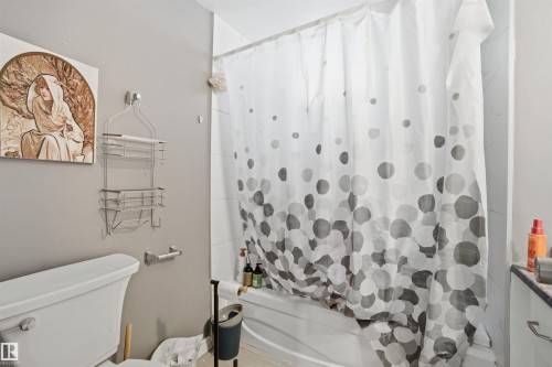 Bathroom featuring a white toilet, a bathtub with a white shower curtain, and a wall-mounted towel rack - 5208 90 Avenue, Edmonton, AB - Indoor Photo Showing Bathroom