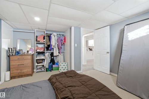 This room features a neutral carpet, light blue walls, and a drop ceiling with recessed lighting - 5208 90 Avenue, Edmonton, AB - Indoor Photo Showing Bedroom