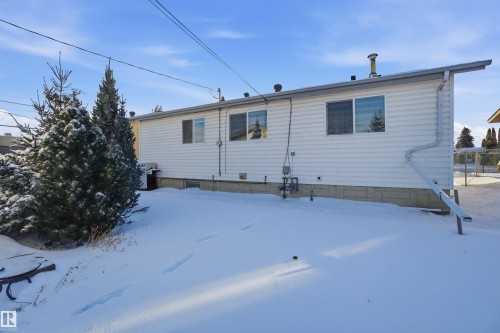 The property features white siding and a foundation with stone detailing - 5208 90 Avenue, Edmonton, AB - Outdoor With Exterior