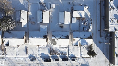 Aerial view showcasing properties with snow-covered rooftops, yards, and roadways - 5208 90 Avenue, Edmonton, AB - Outdoor With View