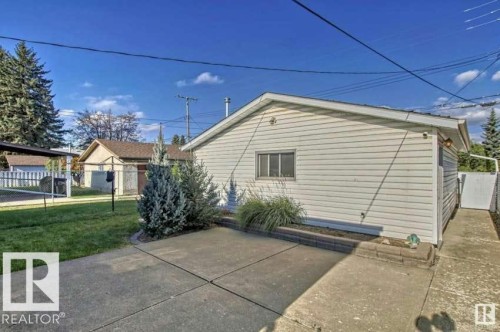 The property includes a concrete patio area and a small garden bed with greenery - 5208 90 Avenue, Edmonton, AB - Outdoor