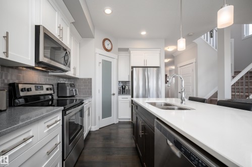 Contemporary kitchen with white upper and dark lower cabinetry - 2704 Koshal Place, Edmonton, AB - Indoor Photo Showing Kitchen With Double Sink With Upgraded Kitchen