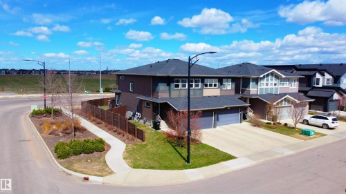 Contemporary townhome featuring multiple rooflines, a two-car garage, paved driveway, and a fenced backyard - 2704 Koshal Place, Edmonton, AB - Outdoor With Facade
