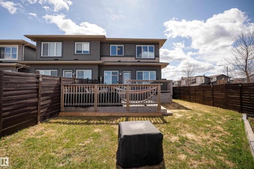 Expansive backyard featuring a wood deck, horizontal slat fencing, and a grassy area - 2704 Koshal Place, Edmonton, AB - Outdoor
