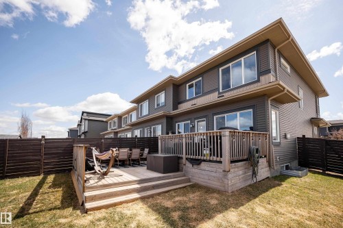 Rear exterior featuring a multi-level wood deck, dark wood fencing, and a grass yard - 2704 Koshal Place, Edmonton, AB - Outdoor With Deck Patio Veranda With Exterior