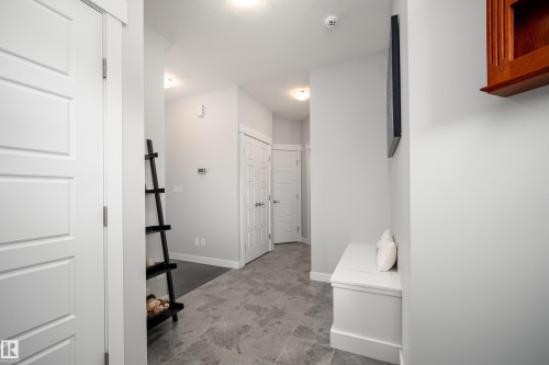 Spacious entry with gray-toned tile flooring, recessed lighting, and crisp white trim - 2704 Koshal Place, Edmonton, AB - Indoor Photo Showing Other Room