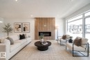 Spacious living area featuring a linear electric fireplace with wood-finish paneling, large picture windows, recessed lighting, and light wood-finish flooring - 86 Blackbird Bend, Fort Saskatchewan, AB  - Indoor Photo Showing Living Room With Fireplace 