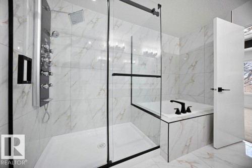 Luxury bathroom featuring a glass-enclosed shower with a multi-function shower panel and a built-in bathtub, all complemented by marble-patterned wall and floor tiles - 12307 91 St Nw, Edmonton, AB - Indoor Photo Showing Bathroom