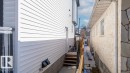 The property features white horizontal siding and a wooden staircase with handrails - 12307 91 St Nw, Edmonton, AB  - Outdoor With Exterior 