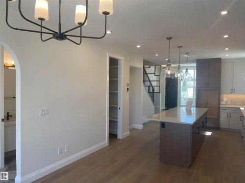 Modern kitchen featuring a large island with a quartz countertop, pendant lighting, and recessed lighting throughout - 14344 92A Avenue, Edmonton, AB - Indoor Photo Showing Kitchen