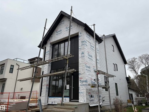 Contemporary architectural design featuring dark vertical siding and a prominent gabled roofline - 14344 92A Avenue, Edmonton, AB - Outdoor