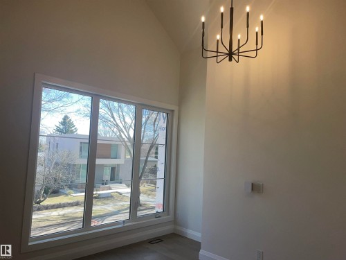 Light wood-finish flooring with white baseboards - 14344 92A Avenue, Edmonton, AB - Indoor Photo Showing Other Room