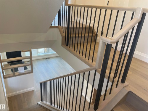 Two-story foyer featuring a light wood-finish staircase with black metal balusters and matching railing - 14344 92A Avenue, Edmonton, AB - Indoor Photo Showing Other Room