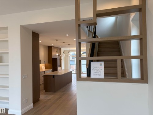 Archway entry to a mudroom featuring white built-in cabinetry with hooks and shelving - 14344 92A Avenue, Edmonton, AB - Indoor Photo Showing Other Room
